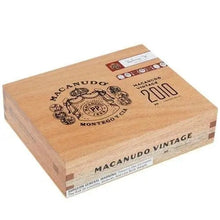 Load image into Gallery viewer, Macanudo Vintage 2010 Torpedo cigar with medium flavor, featuring a smooth wrapper and detailed band, displayed on a wooden surface.